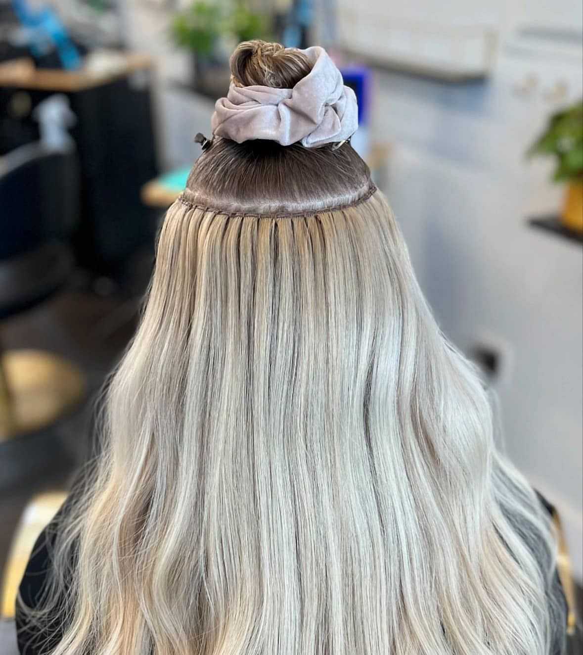 Blonde hair with extensions in a salon setting.