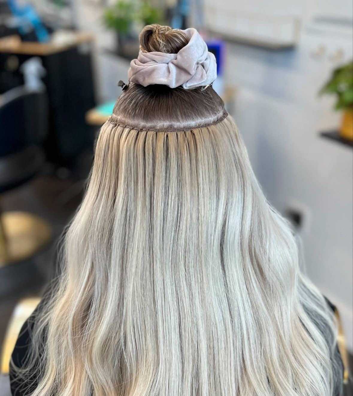Blonde hair with extensions in a salon setting.